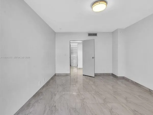 a bedroom with a large bed and a flat screen tv