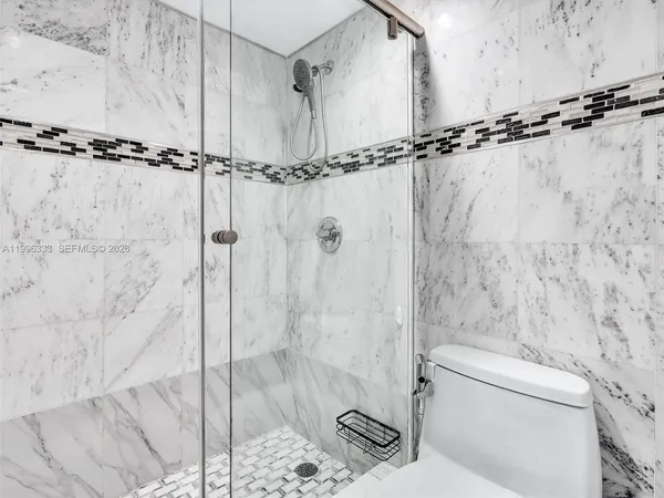 a bathroom with a shower toilet and sink