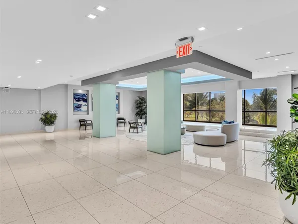 a living room with furniture a flat screen tv and a refrigerator