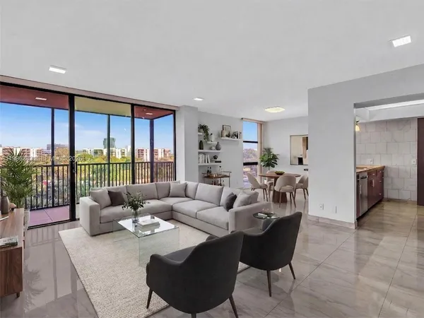 a living room with furniture large windows and a table
