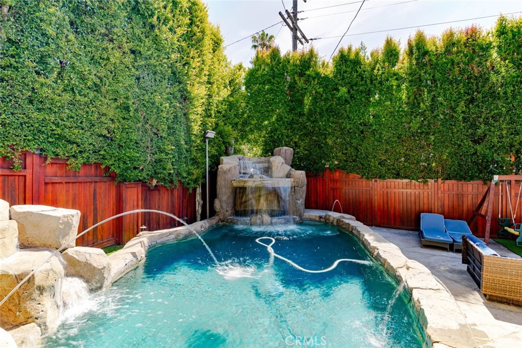 660 Woodbury Road Glendale, CA 91206 - Photo 29 of 45 a view of a backyard with table and chairs potted plants and wooden fence