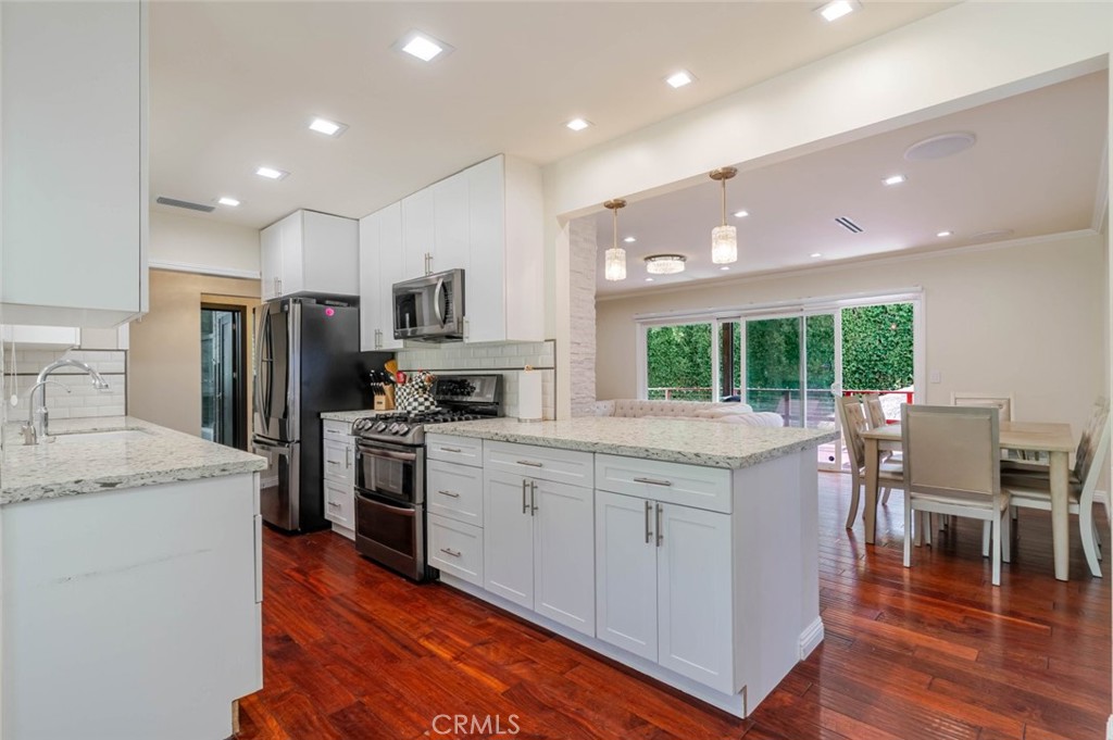 660 Woodbury Road Glendale, CA 91206 - Photo 9 of 45 a kitchen with a sink a stove a refrigerator and chairs