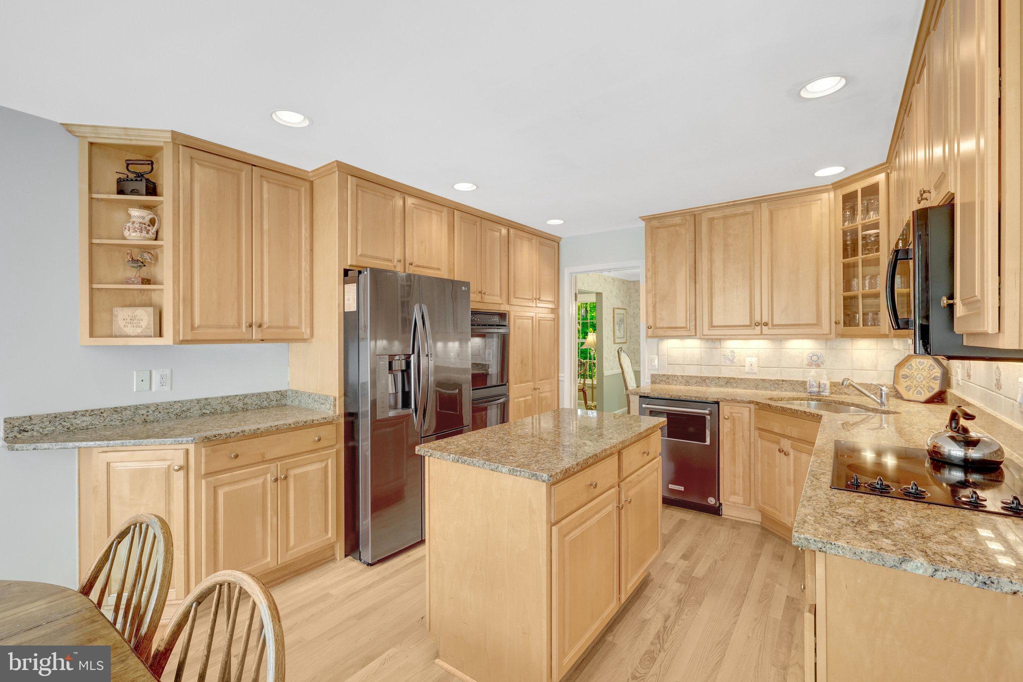 2042 Carrhill Road Vienna, VA 22181 - Photo 19 of 80 a kitchen with granite countertop a stove top oven a sink dishwasher and a refrigerator with wooden floor