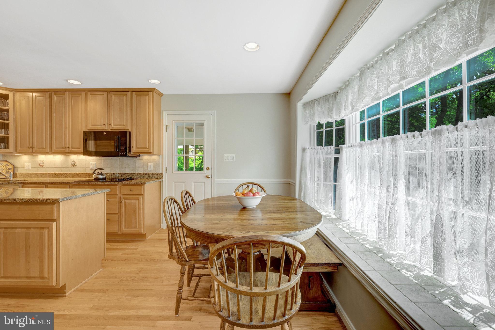 2042 Carrhill Road Vienna, VA 22181 - Photo 25 of 80 a kitchen with granite countertop a stove a sink a microwave a dining table and chairs