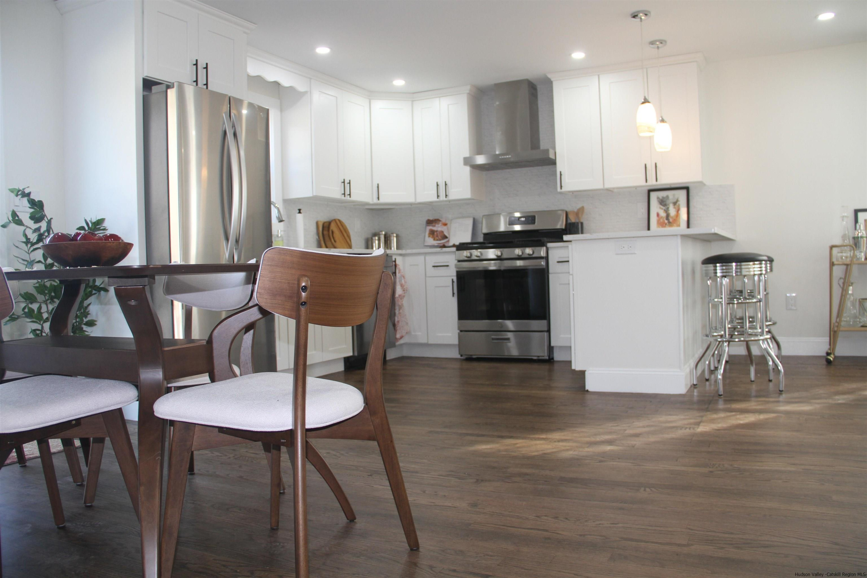 246 Jefferson Heights Catskill, NY 12414 - Photo 10 of 35 a kitchen with stainless steel appliances granite countertop a stove a sink a refrigerator and a dining table with wooden floor