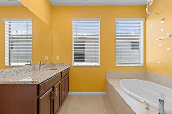 a bathroom with a granite countertop sink and a bathtub