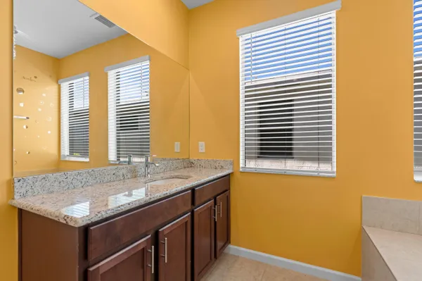 a bathroom with a granite countertop sink and a window