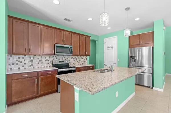a kitchen with kitchen island granite countertop stainless steel appliances a sink stove and refrigerator