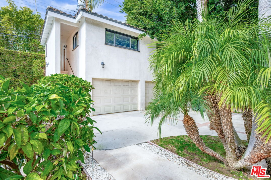 607 North Hillcrest Road Beverly Hills, CA 90210 - Photo 12 of 16 a front view of a house with a yard