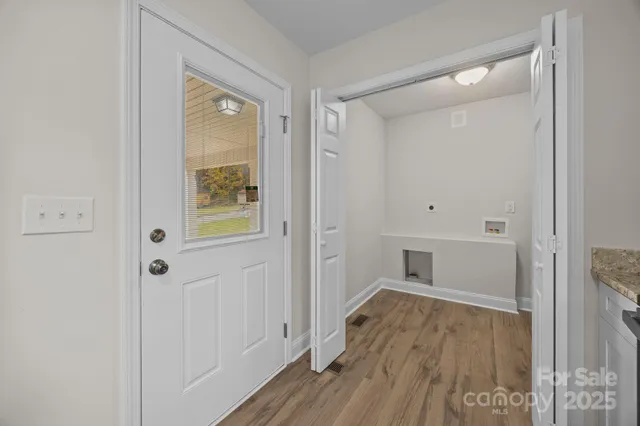 a view of a hallway with wooden floor and closet area