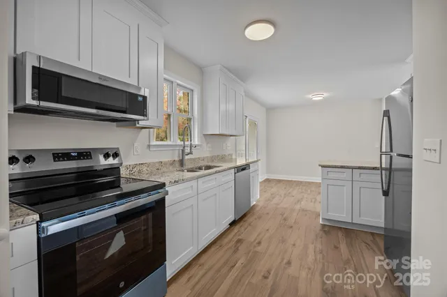 a kitchen with stainless steel appliances a stove microwave and sink