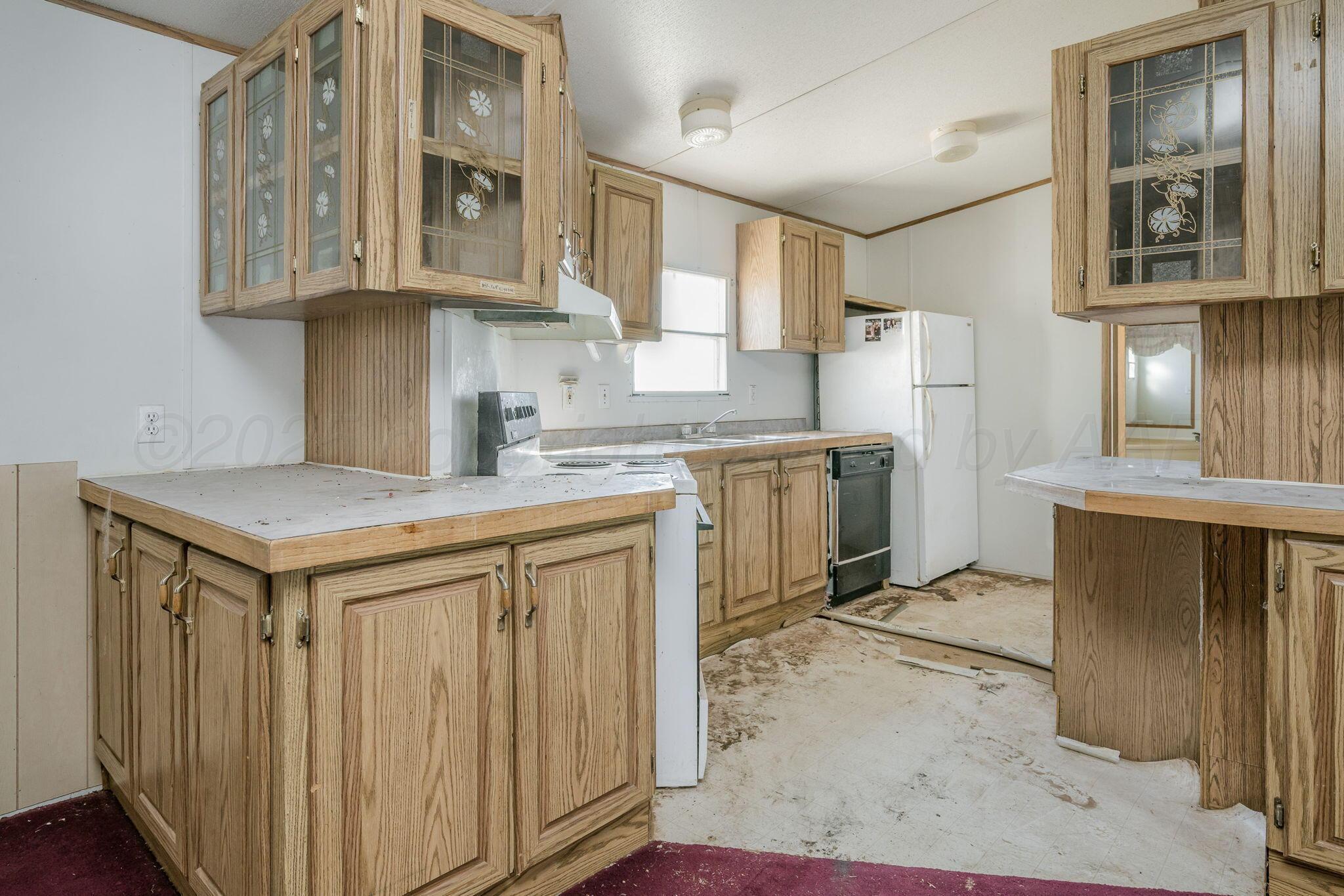 1061 Tascosa Road Amarillo, TX 79124 - Photo 10 of 31 a kitchen with stainless steel appliances granite countertop a refrigerator a sink dishwasher and white cabinets with wooden floor