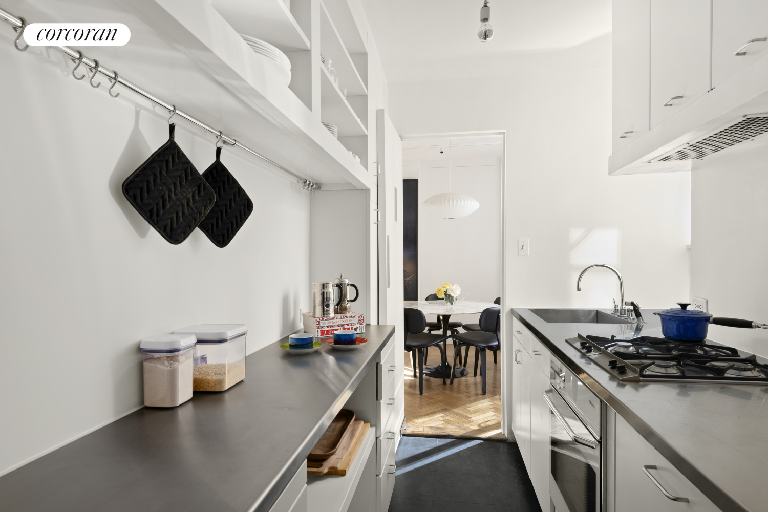 24 West 55th Street, Unit 7F Manhattan, NY 10019 - Photo 4 of 10 a kitchen with a sink a stove and chairs
