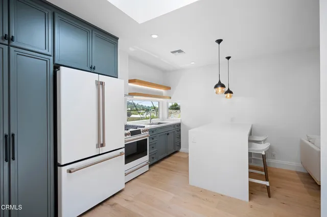 a white refrigerator freezer and a stove sitting inside of a kitchen