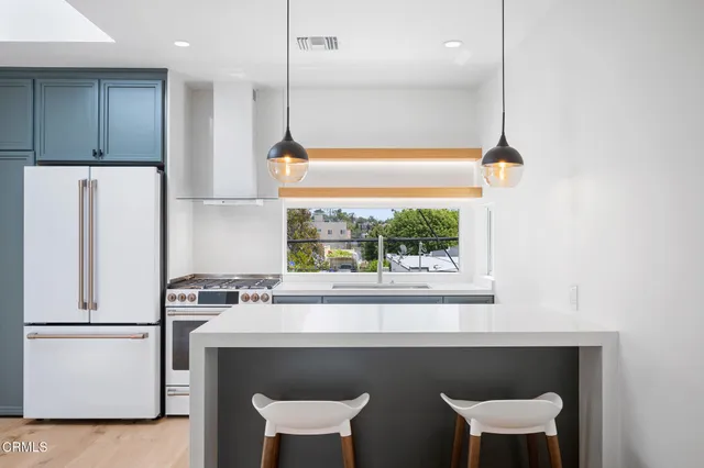 a kitchen with a table chairs refrigerator and window