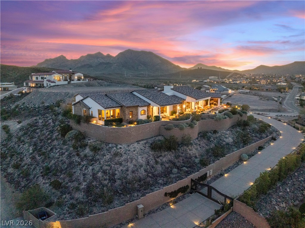 1123 Christian Road Henderson, NV 89002 - Photo 79 of 94 Perched on a hill, this desert dwelling offers captivating mountain views under an evening sky.
