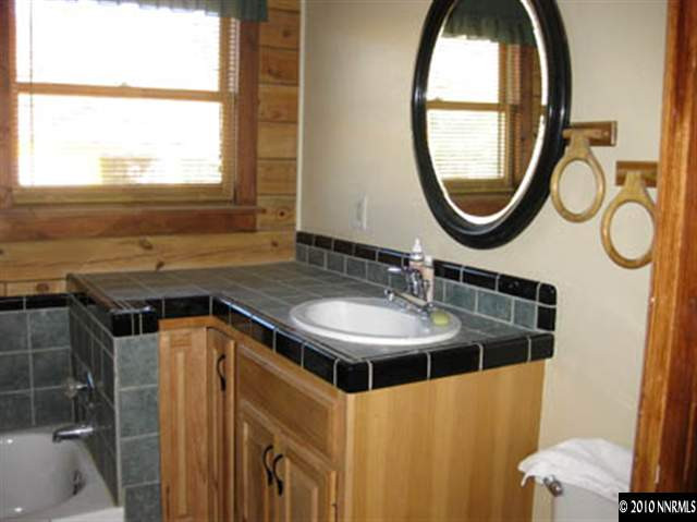 6400 Lost Springs Road Reno, NV 89510 - Photo 9 of 13 a bathroom with a sink a mirror and a window
