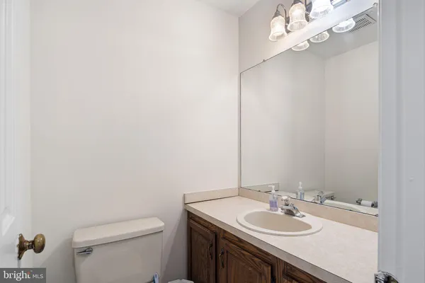 a bathroom with a granite countertop sink a toilet and a mirror