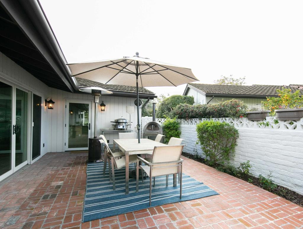 6145 La Flecha, Unit 4 Rancho Santa Fe, CA 92067 - Photo 4 of 26 a view of a roof deck with table and chairs under an umbrella