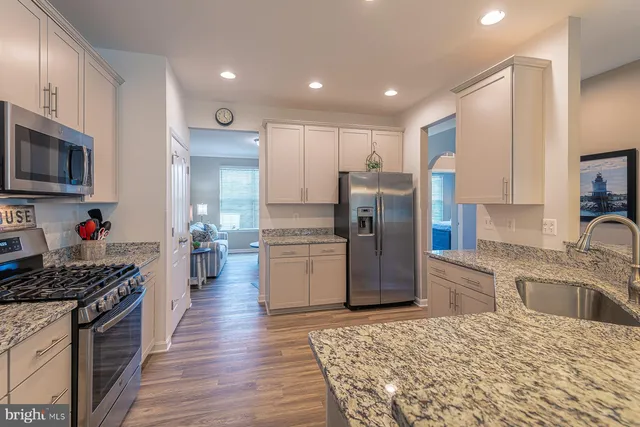 a kitchen with a sink cabinets and wooden floor