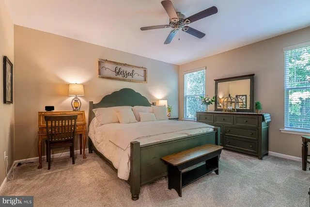 a bedroom with a bed a chandelier and a flat tv