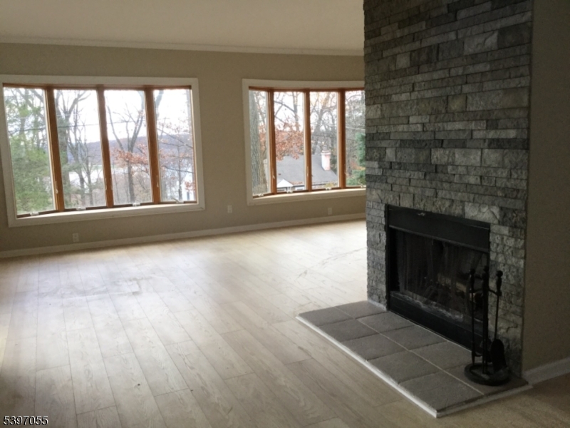 592 Dell Road Landing, NJ 07850 - Photo 5 of 39 an empty room with wooden floor fireplace and windows
