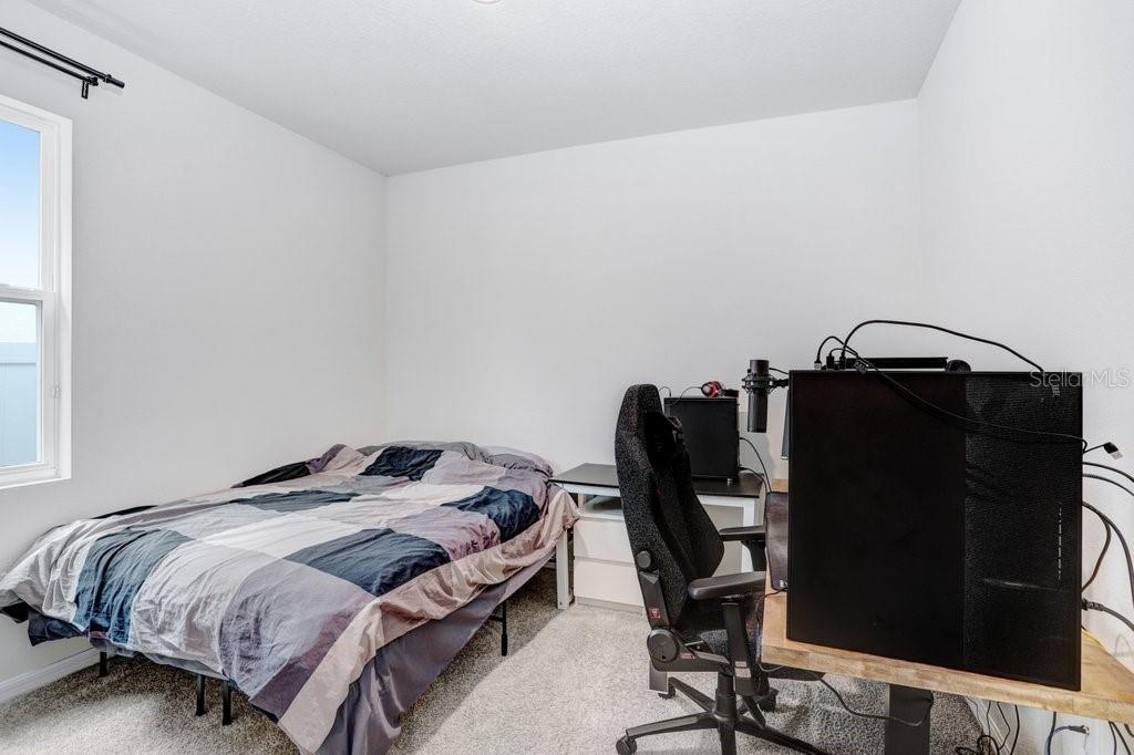 16619 Goose Ribbon Place Wimauma, FL 33598 - Photo 20 of 38 a bedroom with a bed and a chair