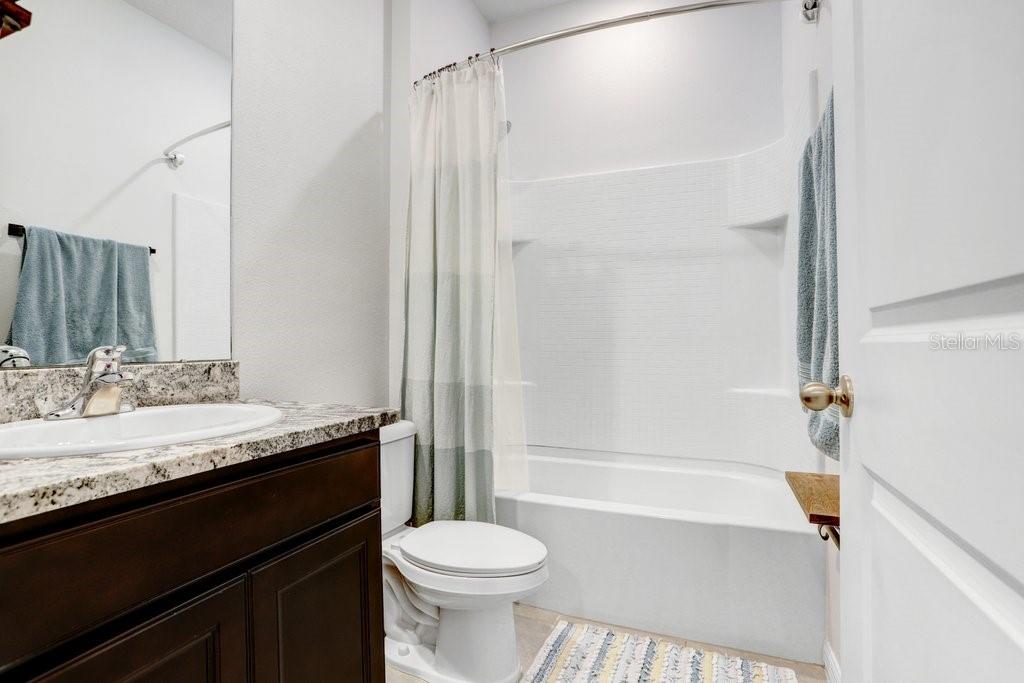 16619 Goose Ribbon Place Wimauma, FL 33598 - Photo 23 of 38 a bathroom with a granite countertop sink toilet and shower