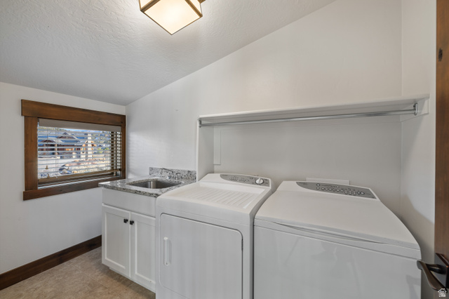 707 Chimney Rock Road, Unit 247 Heber City, UT 84032 - Photo 39 of 64 Washroom with lofted ceiling, washer and clothes dryer, cabinet space, light tile patterned floors, and a textured ceiling