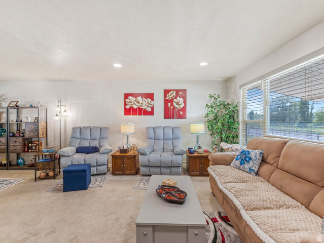 1502 North 475 West Sunset, UT 84015 - Photo 5 of 23 Carpeted living area featuring recessed lighting, a large window with horizontal blinds, and textured walls