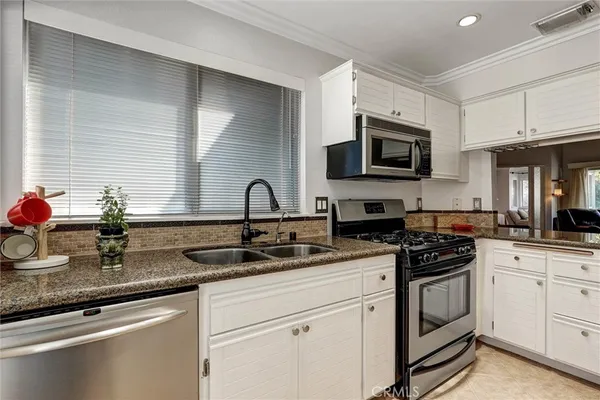 a kitchen with appliances a sink and cabinets