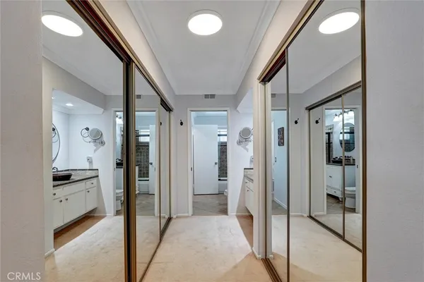a view of a hallway with wooden floor and a bathroom