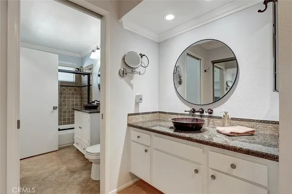 a bathroom with a granite countertop toilet a sink and a mirror
