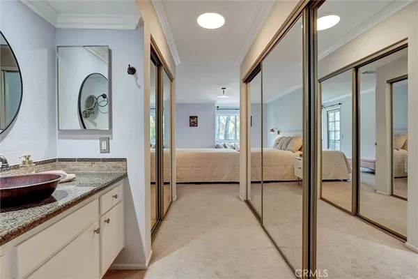 a en suite bathroom with a granite countertop sink and a mirror