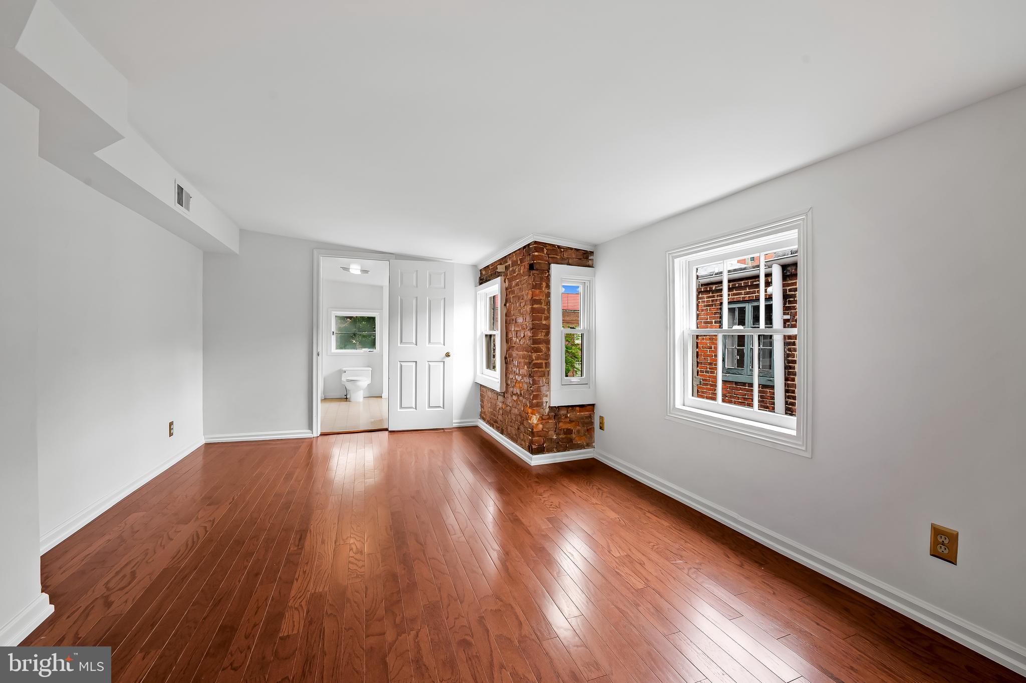 1431 Park Avenue Baltimore, MD 21217 - Photo 34 of 55 an empty room with wooden floor and windows