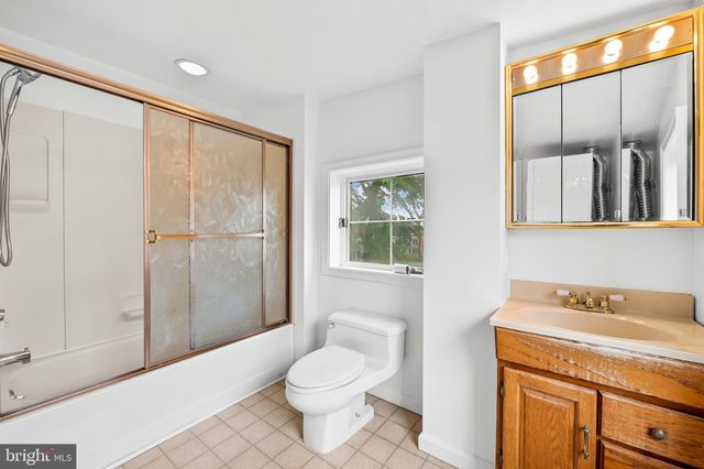 a spacious bathroom with a granite countertop sink a toilet and a shower