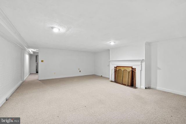 a view of an empty room with a fireplace and a window