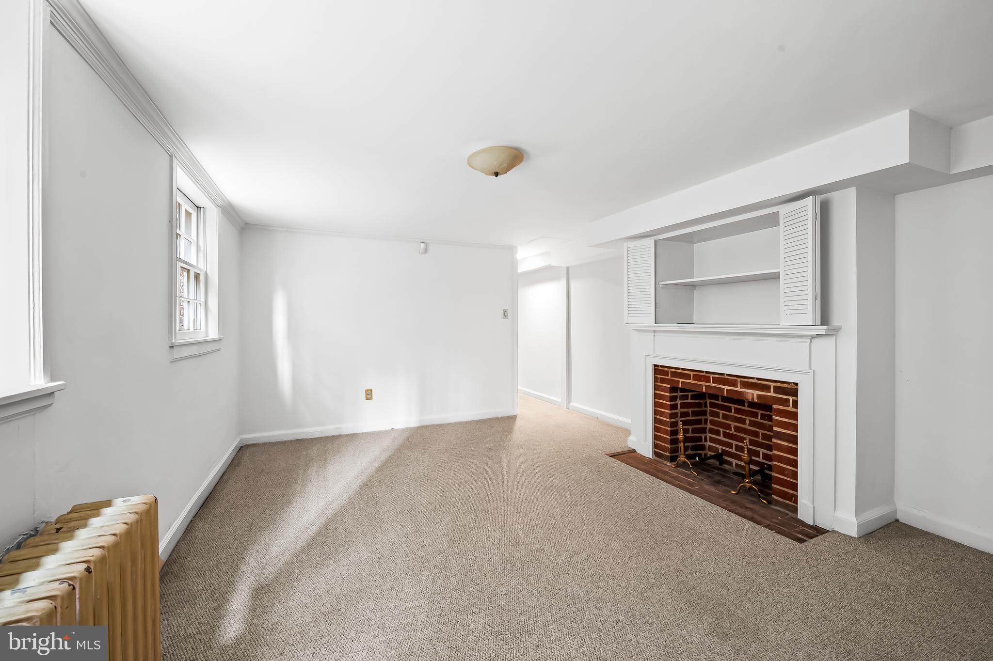 1431 Park Avenue Baltimore, MD 21217 - Photo 42 of 55 a view of an empty room with a fireplace and a window