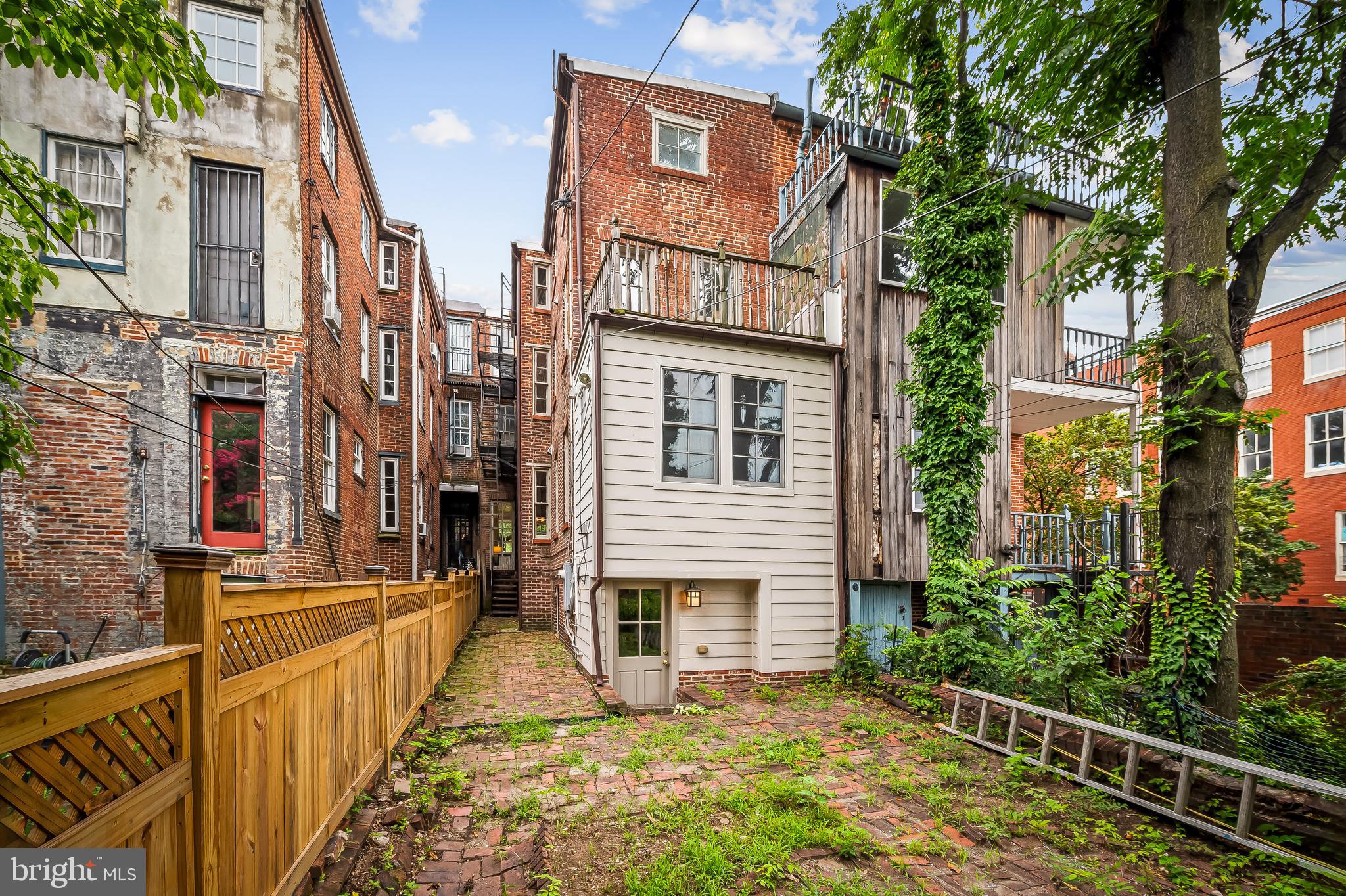 1431 Park Avenue Baltimore, MD 21217 - Photo 50 of 55 a view of a brick house with many windows next to a yard