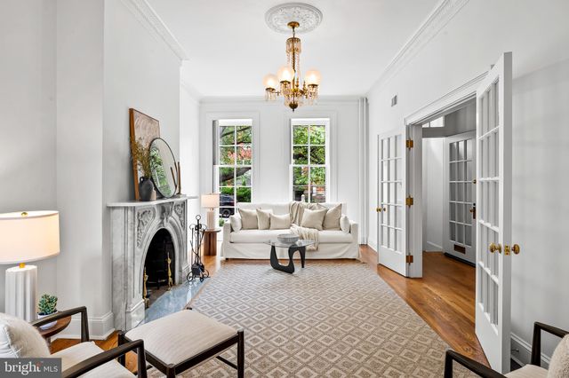 a living room with furniture a fireplace and a chandelier