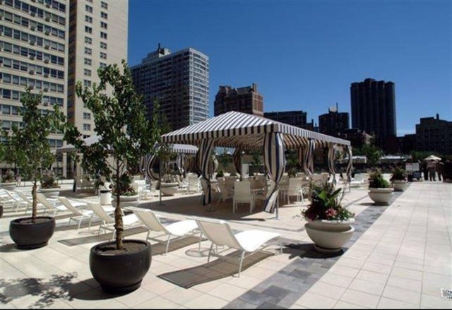 655 West Irving Park Road, Unit 4317 Chicago, IL 60613 - Photo 24 of 25 a view of a patio with table and chairs potted plants