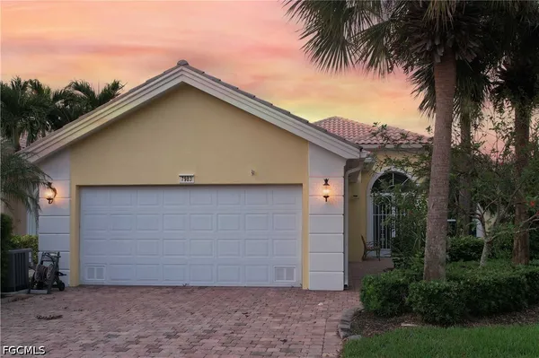 a view of a house with a yard plants and palm trees