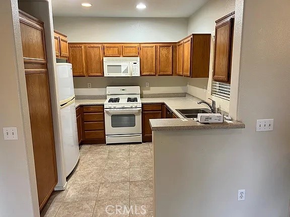 a kitchen with stainless steel appliances granite countertop a refrigerator a sink and a stove