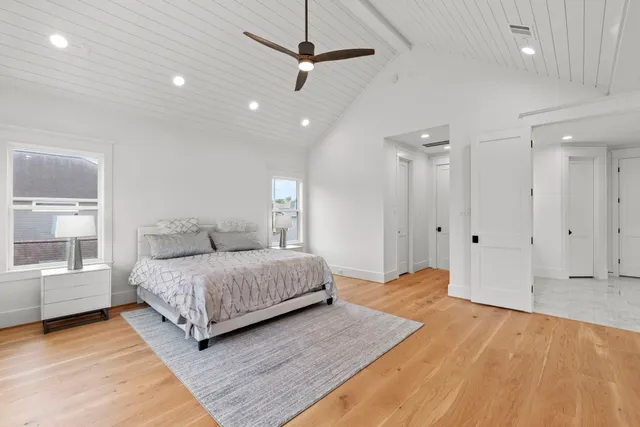 a spacious bedroom with a bed and a chandelier