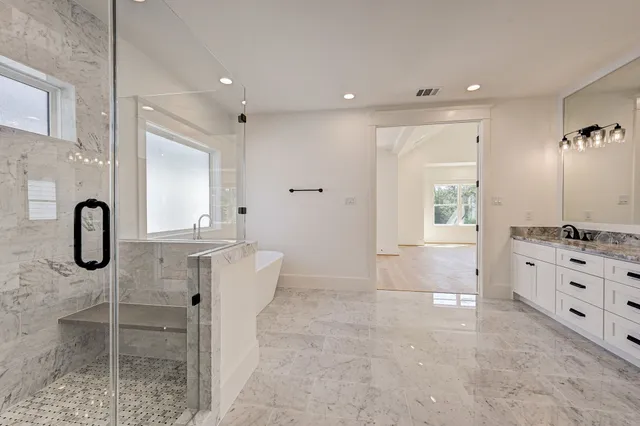 a bathroom with a granite countertop sink a toilet and shower