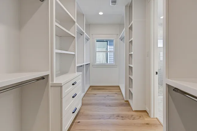 a hallway with white cabinets and white appliances