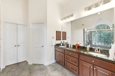 a spacious bedroom with a bed and a chandelier