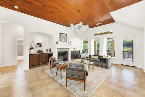 a living room with furniture a fireplace and a chandelier