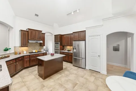 a living room with furniture a chandelier and a flat screen tv