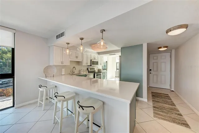 a kitchen with sink a microwave and cabinets